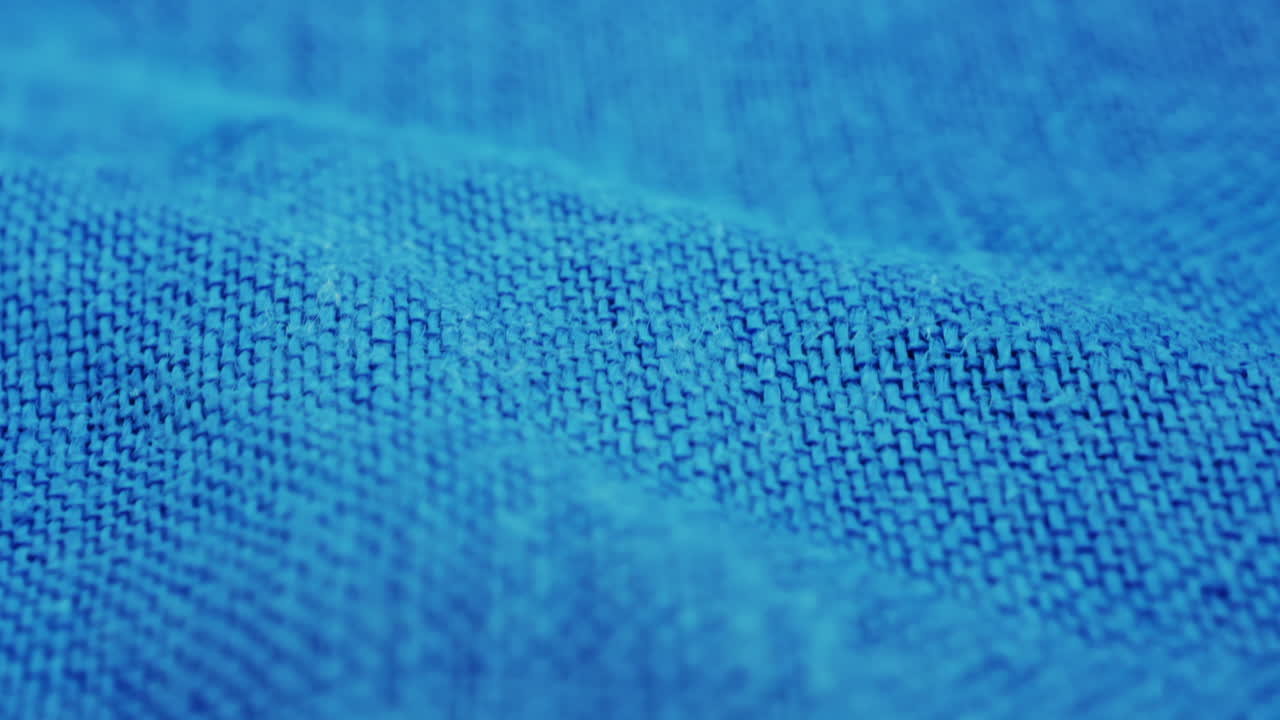 Close up of blue denim fabric texture showing fine threads and detailed textile pattern
