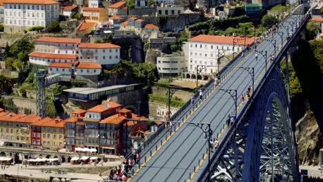 tourists crossing luís i bridge with crowds and market stalls below, porto, portugal 4k slowmo cinematic aerial summer mediterranean city