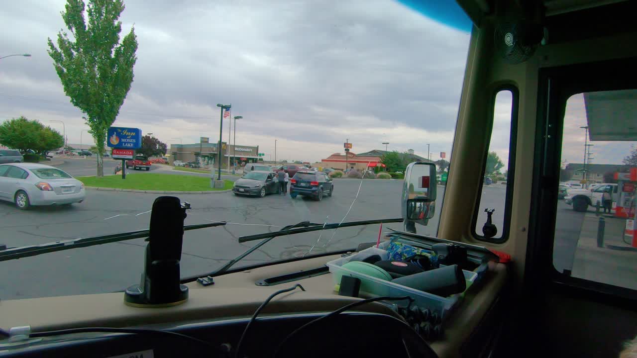 주차 중인 a급 rv 운전자, 구름이 많고 바람이 불는 날 주차장과 바쁜 전면 도로의 전망