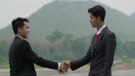 businessmen shaking hands outdoors