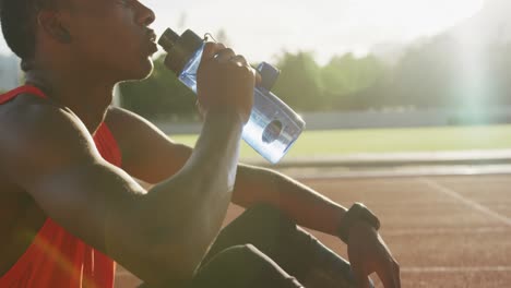 disabled mixed race man with prosthetic legs sitting on racing track