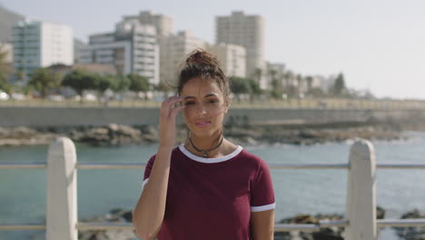 portrait-of-young-beautiful-hispanic-woman-looking-vulnerable-touching-hair-on-seaside-background