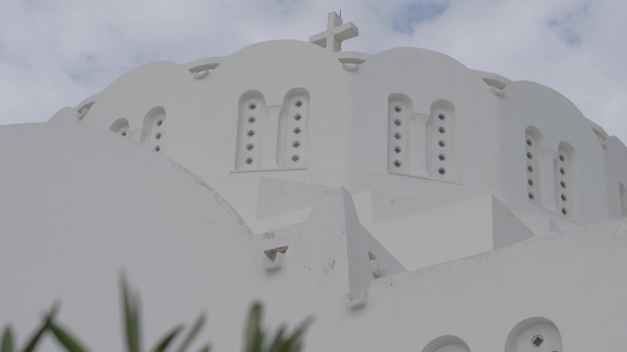 Bianche cupole cicladiche di una cattedrale ortodossa contro un cielo nuvoloso, Fira, Santorini, Grecia