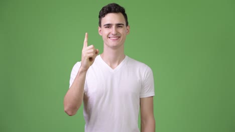 young handsome man pointing finger up