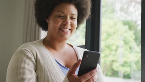 Video-of-happy-plus-size-african-american-woman-using-smartphone