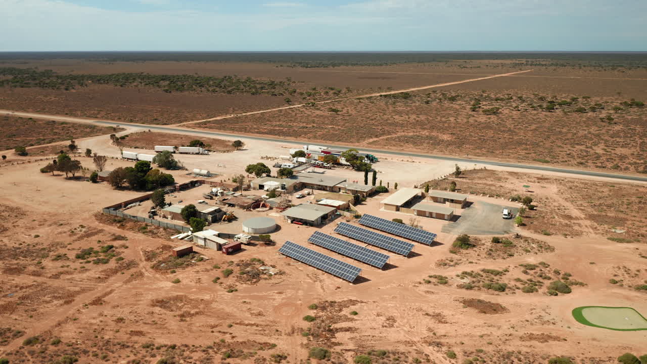 vista aérea sobre una gasolinera y una parada de camiones, en medio del desierto, en australia - órbita, disparo de drones