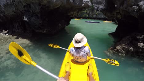 girl kayaking on yellow boat in small lagoon in philippines, entering lagoon