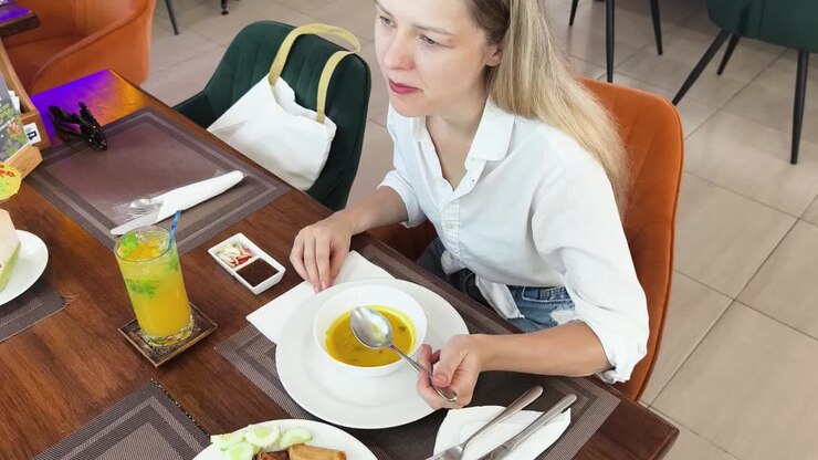 Woman eating soup in a cafe