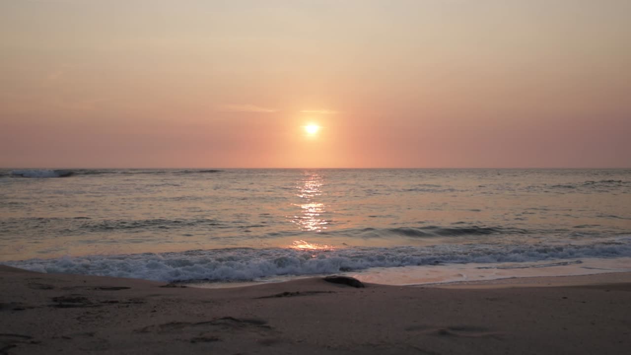 나미비아 의 스 ⁇ 코프문트 에 있는 비어 있는 해변 에서 분홍색 색조 로 해가 지는 것
