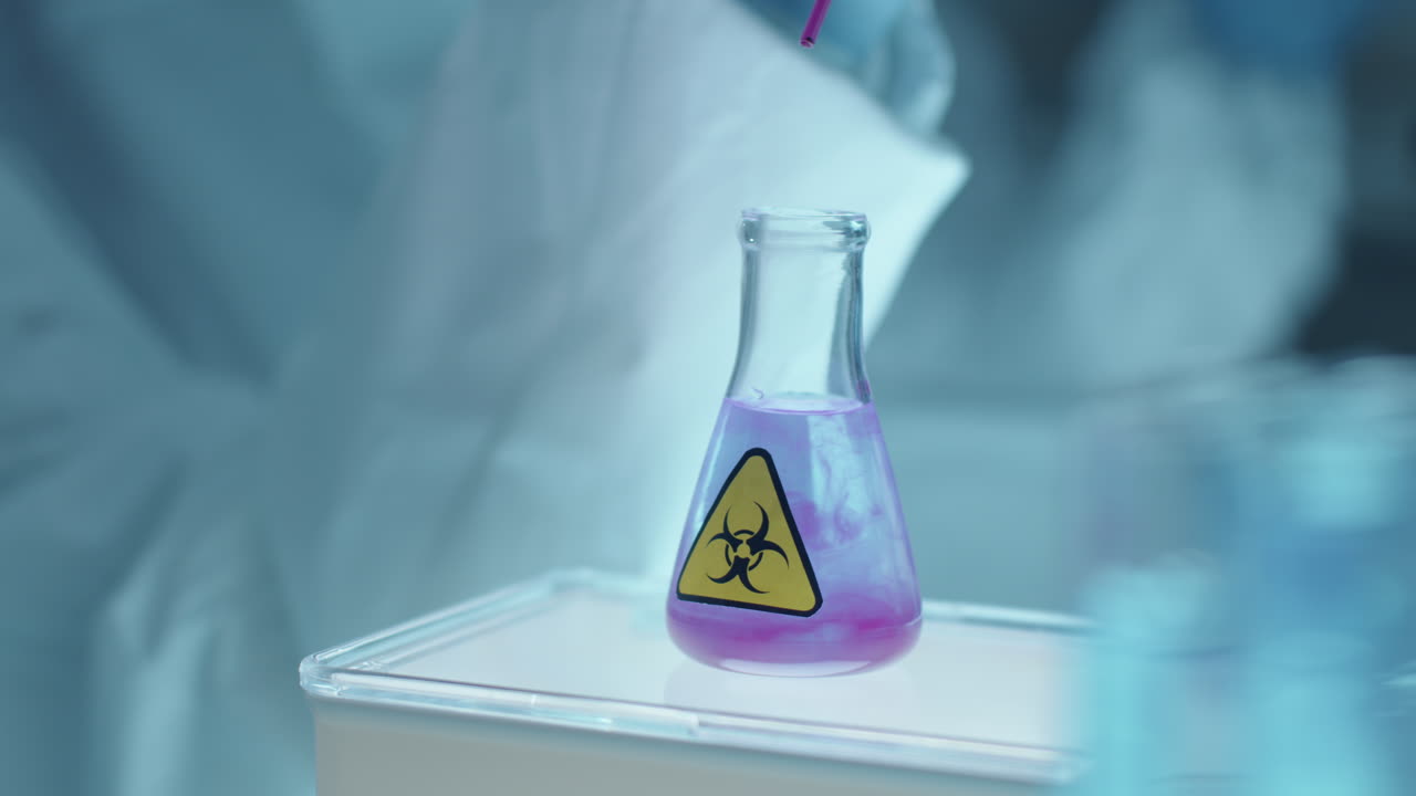 Adding Reagent to Liquid in Flask with Biohazard Sticker in Laboratory