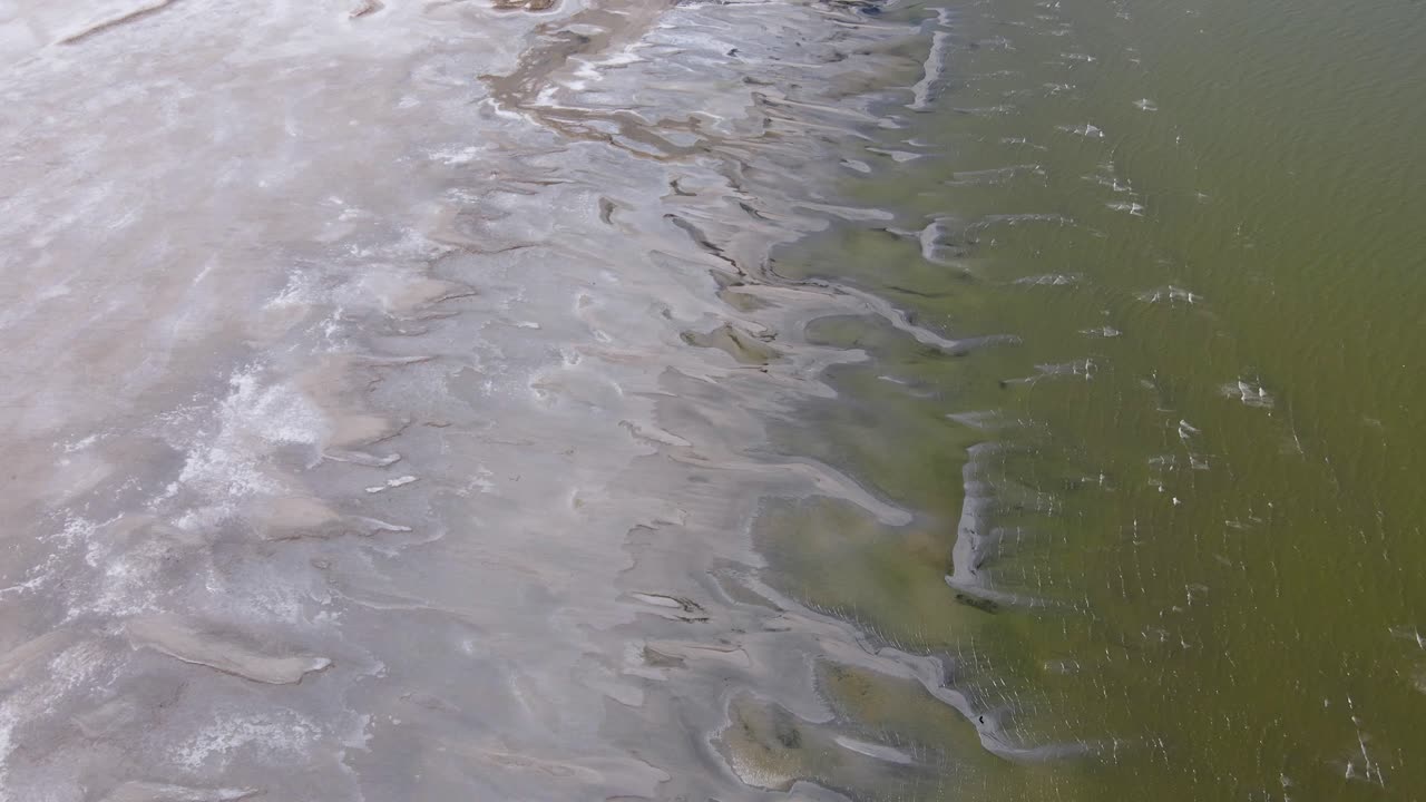 A 4K drone shot over the perfectly flat Bonneville Salt Flats, found west of the Great Salt Lake, in western Utah, with a shallow layer of standing water flooding the vast salt plain&rsquo;s surface