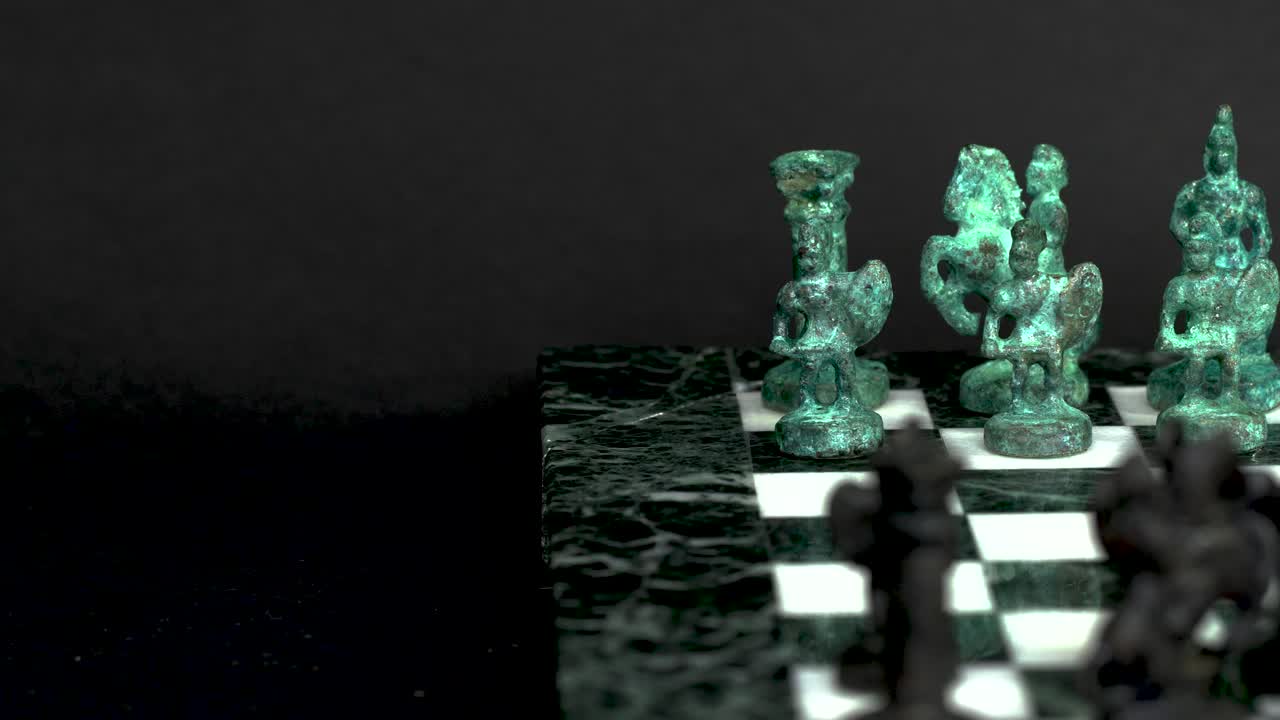Ancient marble chessboard with teal bronce knights as pawns slider macro