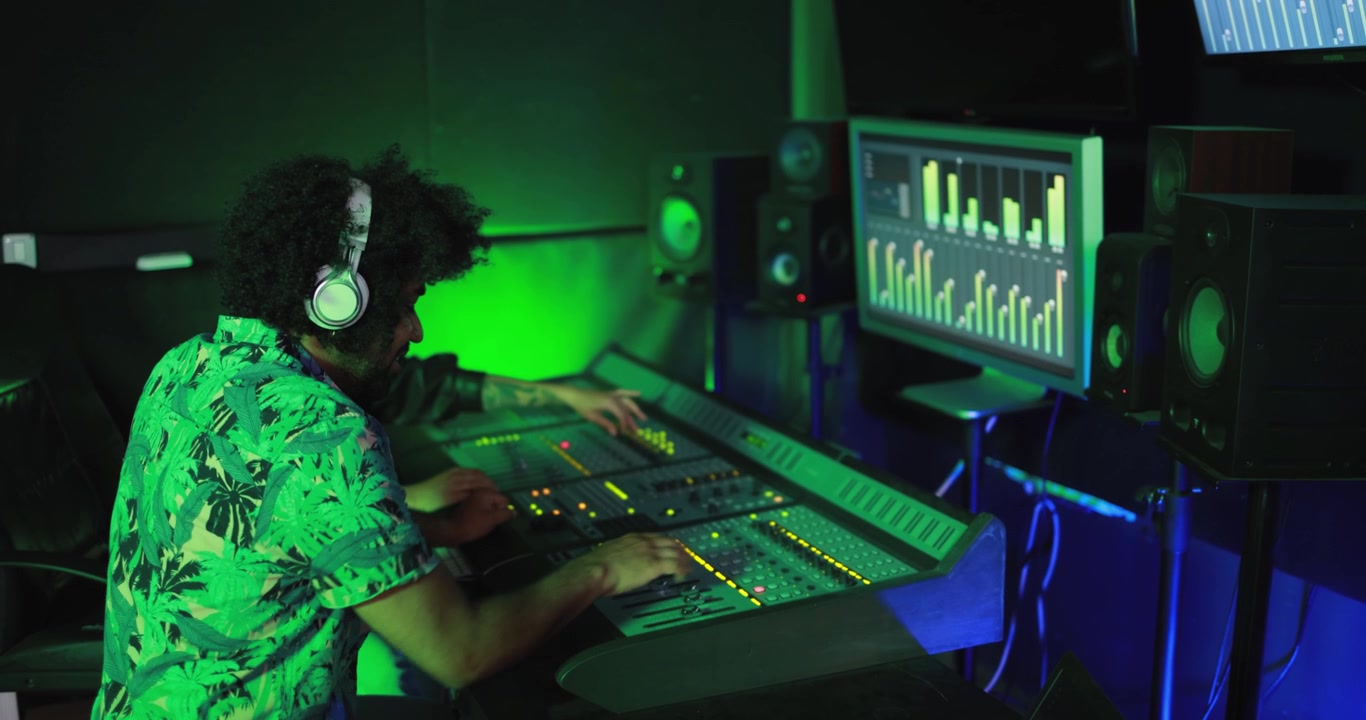 Man Wearing Headphones Working on Sound Mixing Console in Recording Studio