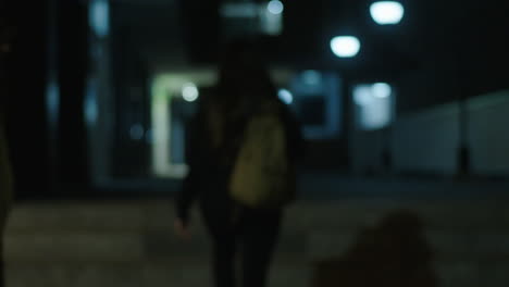 Person Walking Through a Dark Hallway at Night