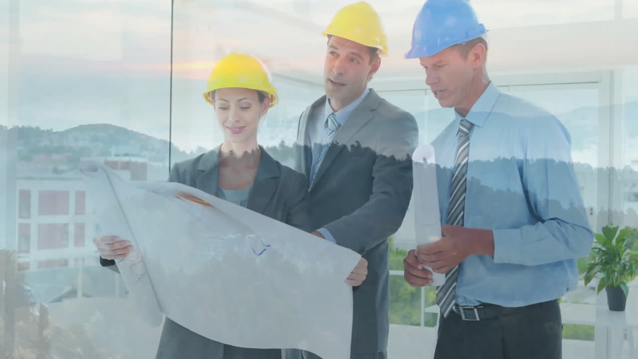 Reviewing blueprints with landscape overlay, architects wearing hard hats at site