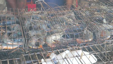 grill cooking river prawns in metal cage on hot charcoal in thailand asia