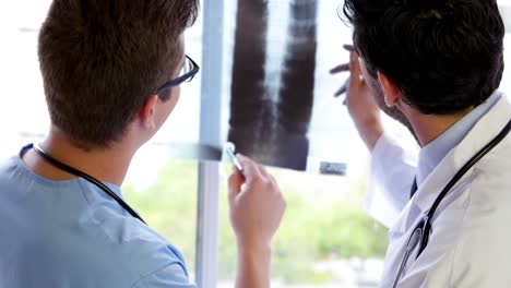 equipo médico de pie y mirando rayos x