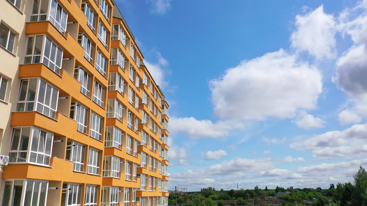 Cropped view of the modern apartment buildings exteriors. Contemporary residential orange and white buildings with outdoor facilities