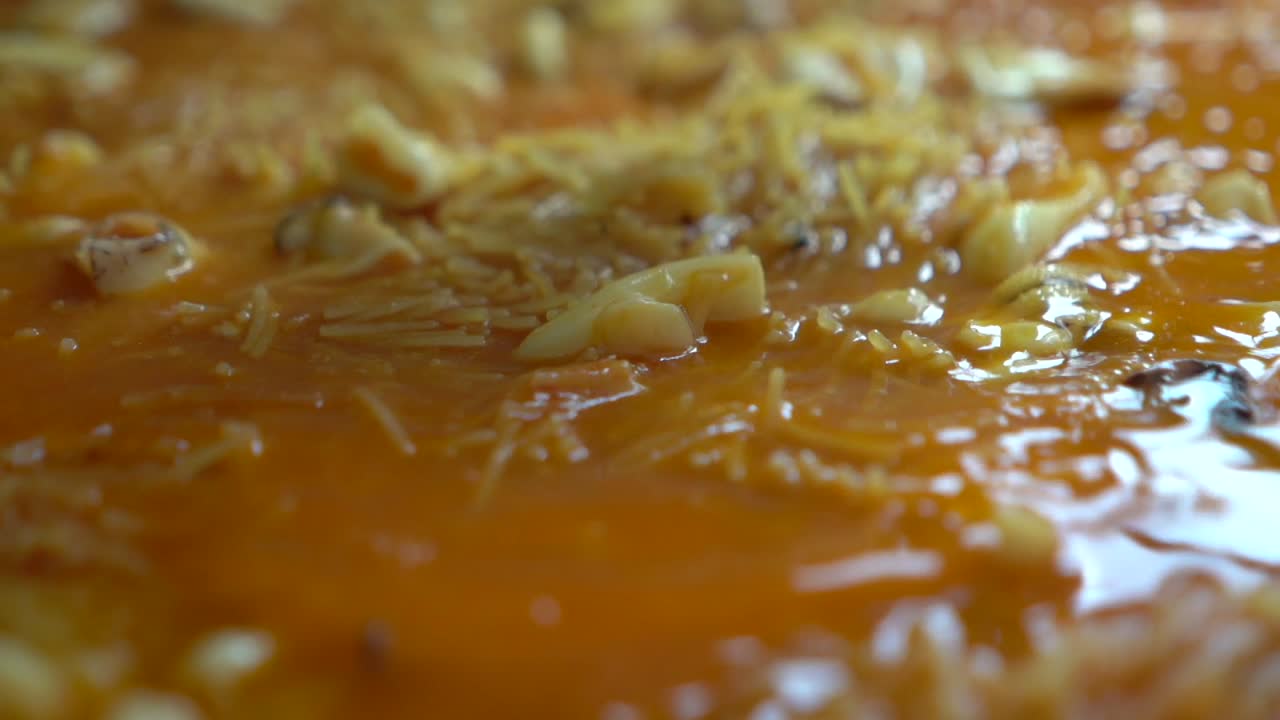 boiling fideua in paellon fish broth with prawns clams squid and noodles