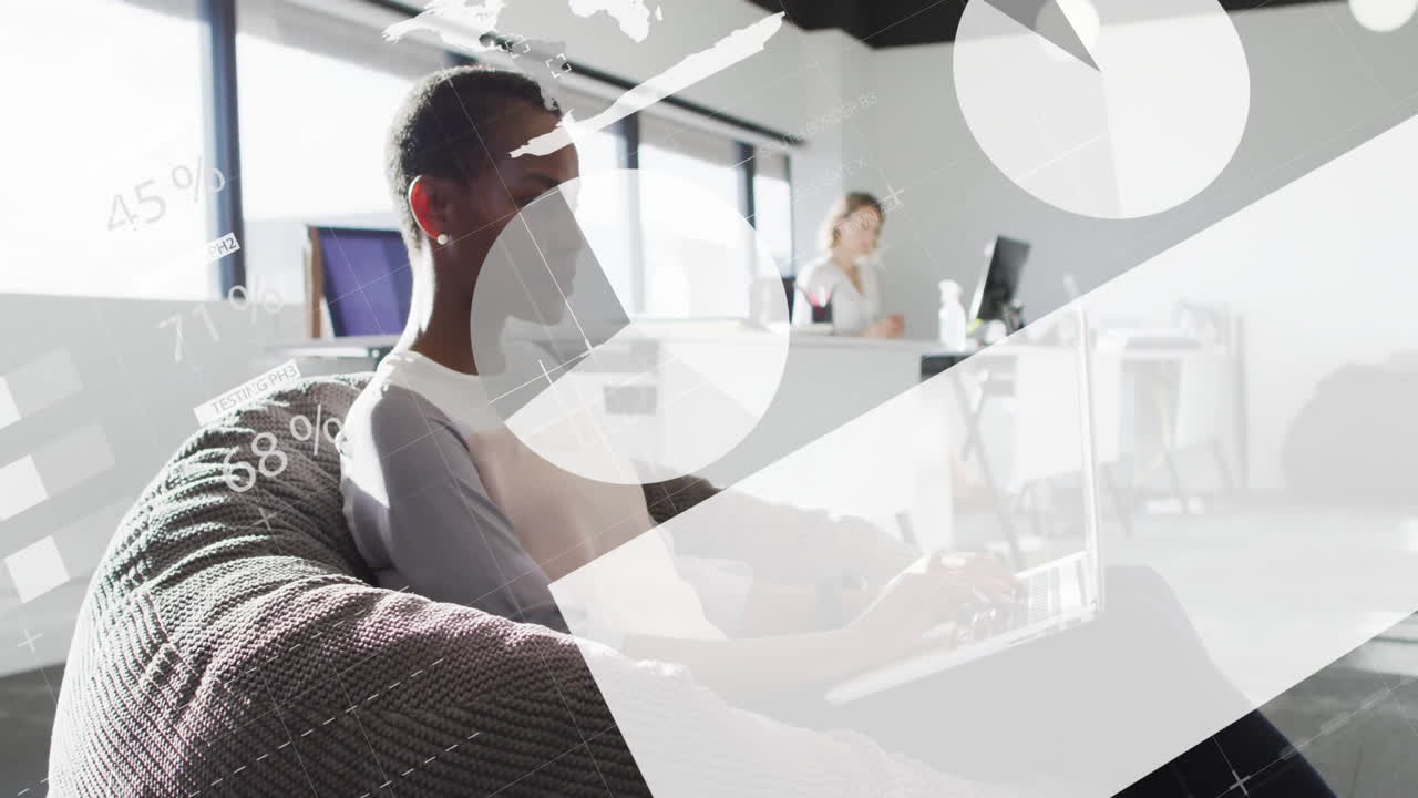 Woman typing on laptop, colleague viewing monitors, animated pie charts floating in business office