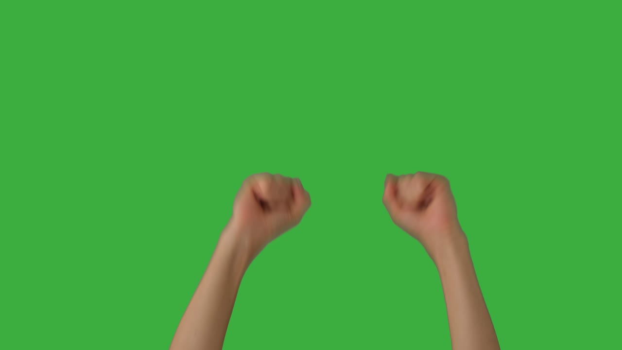 Raised fists of woman cheering over green screen