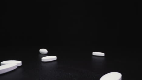 vertiendo medicamentos antivirales blancos en una superficie negra de cerca
