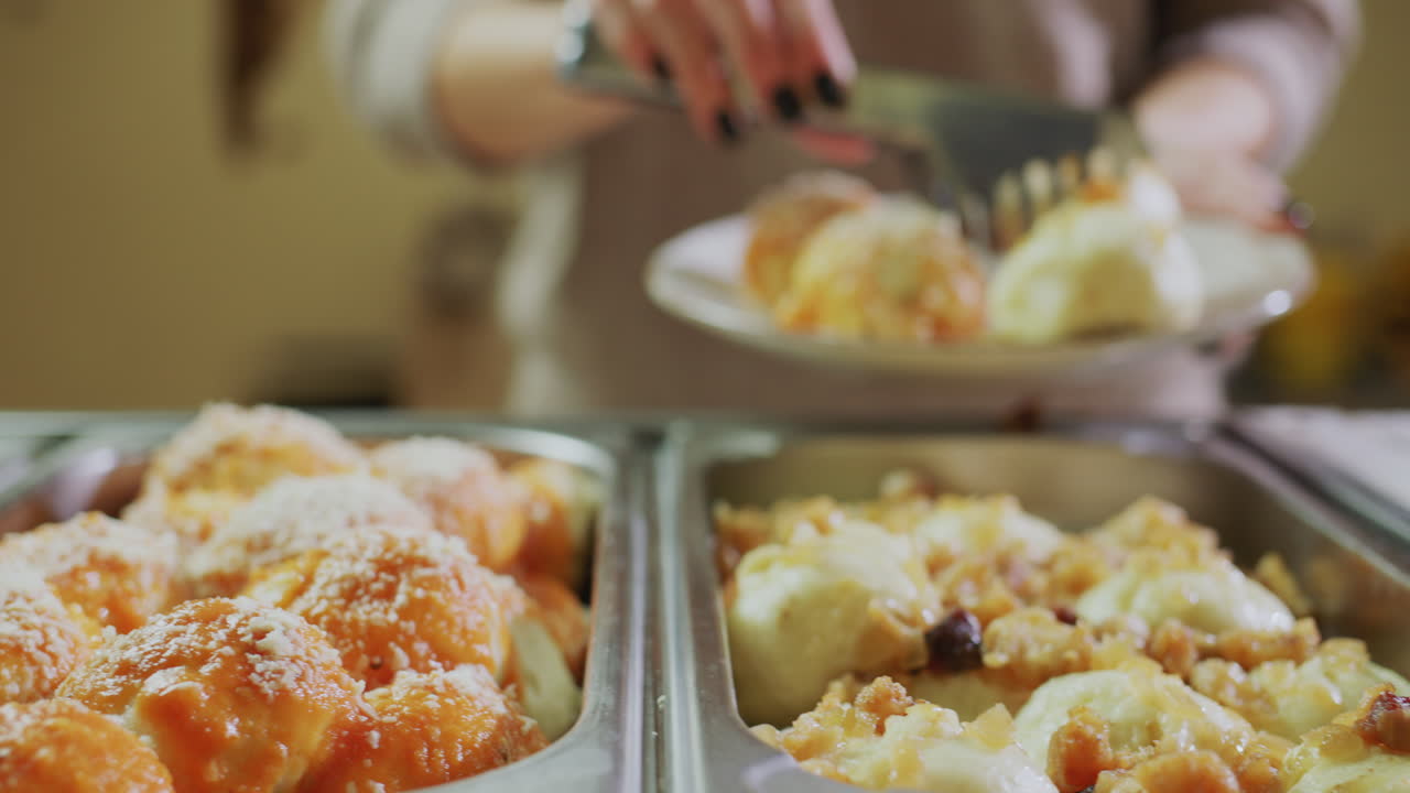 한 여성이 뷔페에서 접시에 음식을 넣습니다. 셀프 서비스 올 인클루시브 레스토랑
