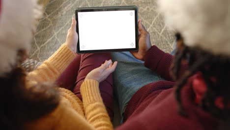 overhead diverse couple making christmas video call on tablet, copy space screen, slow motion