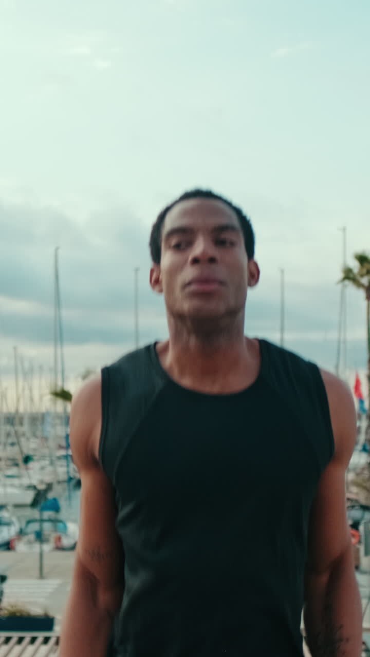 Fit Black Man Doing Jumping Jacks by the Marina