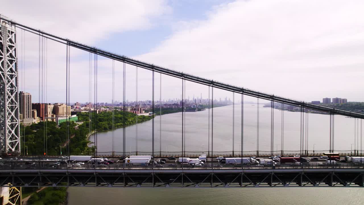Long aerial side view of suspension bridge with traffic