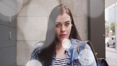 Animation-of-spots-of-light-over-smiling-caucasian-woman-in-city-street