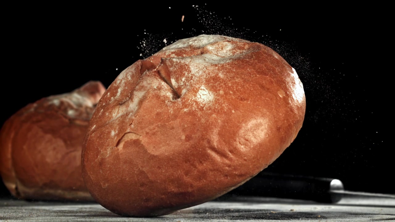 Freshly Baked Bread Loaf Drops onto a Surface in Slow Motion