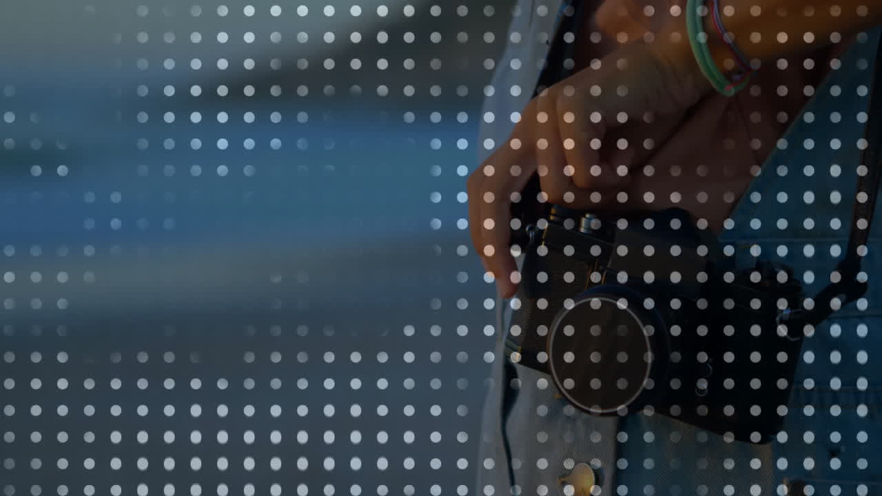 woman holding vintage film camera near water, adding halftone dot overlay for photography marketing