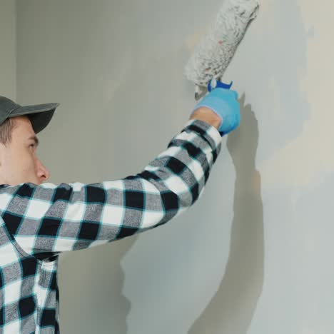 Side-View-Of-Male-Builder-Painting-A-Wall-With-Roller