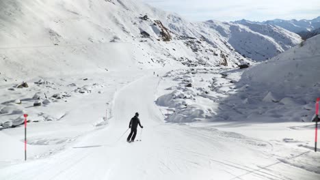 Esquiador-Girando-Lentamente-Cuesta-Abajo-En-Una-Pendiente-Limpia-Y-Blanca-En-Los-Alpes-Austriacos
