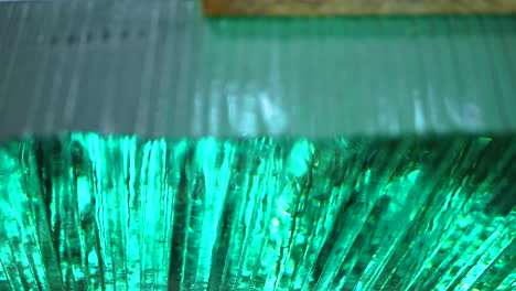 high angle view across green stacked glass panes. pan right , close up