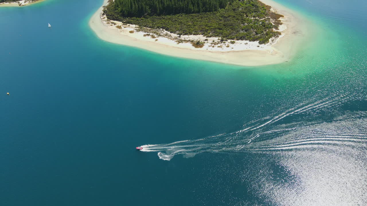 카메라는 보트 뒤의 파도를 힘겹게 타고 물에 흐르는 선을 새기는 서퍼의 우아한 움직임을 포착합니다.