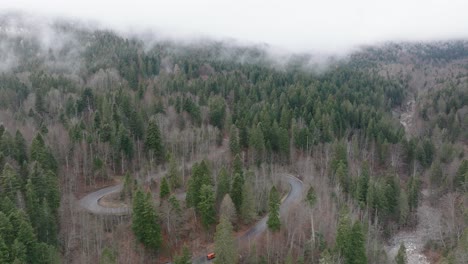 Toma-Aérea-En-El-Clima-Brumoso-De-La-Carretera-De-Curvas-En-El-Corazón-De-Las-Montañas-Bucegi,-Rumania