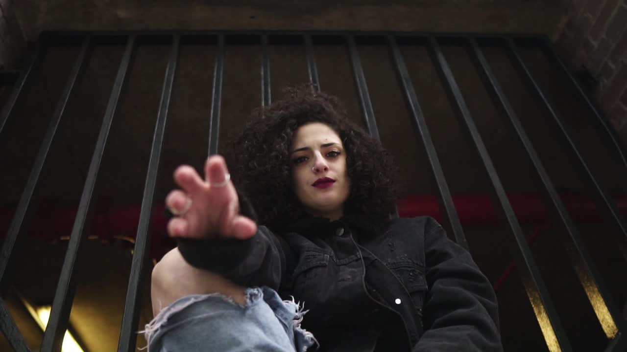 atractiva mujer de moda sentada y alcanzando su mano hacia la cámara, luego gira el movimiento creativo en cámara lenta