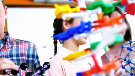 estudiantes experimentando con modelos moleculares en el laboratorio