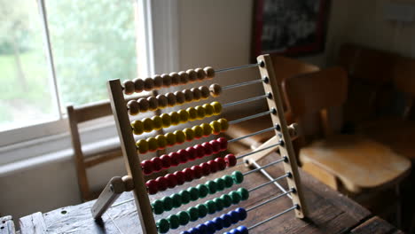 brightly colored abacus on aged wooden desk, a symbol of traditional education and arithmetic