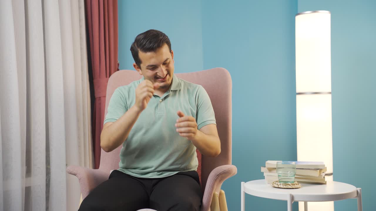 남자가 카메라에 인사를 하고 박수를 치고 있습니다.