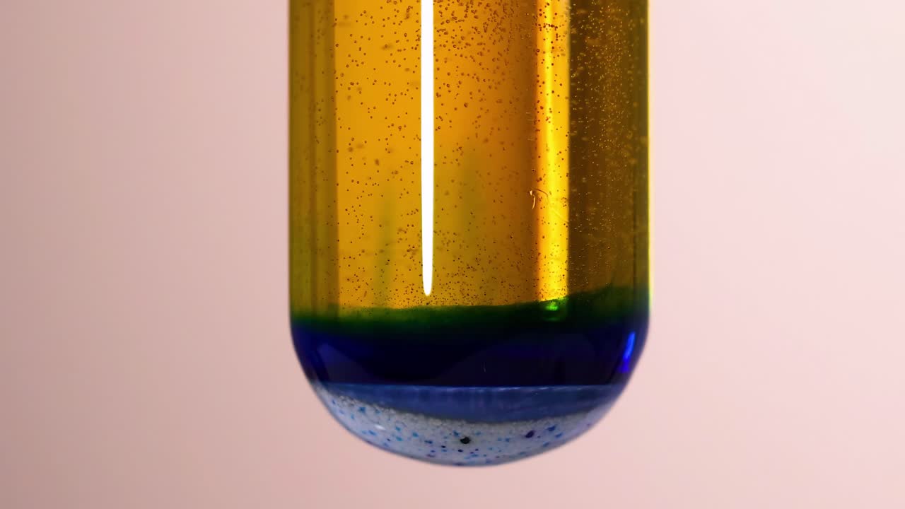 Close-up view of liquid layers in a test tube showing distinct color separation.