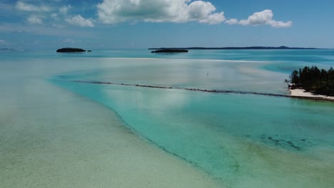 Unberührte-Tropische-Lagune-Mit-Einer-Einsamen-Person,-Die-Auf-Sandebenen-In-Kristallklarem-Wasser-Läuft