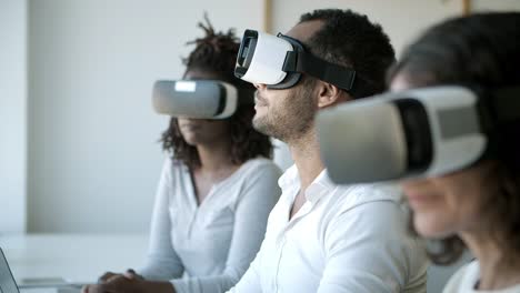 focused people with vr headsets sitting at office