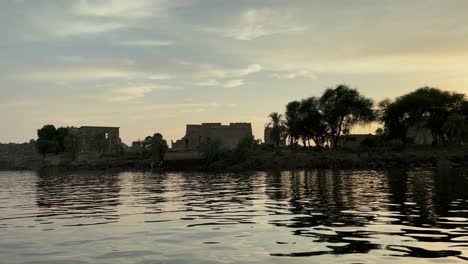 Hermoso-Templo-De-Philae-A-La-Luz-Del-Atardecer-El-Hermoso-Templo-De-Philae-Y-Los-Edificios-Grecorromanos-Se-Ven-Desde-El-Río-Nilo-Un-Templo-Dedicado-A-Isis,-Diosa-Del-Amor-Aswan-Egipto