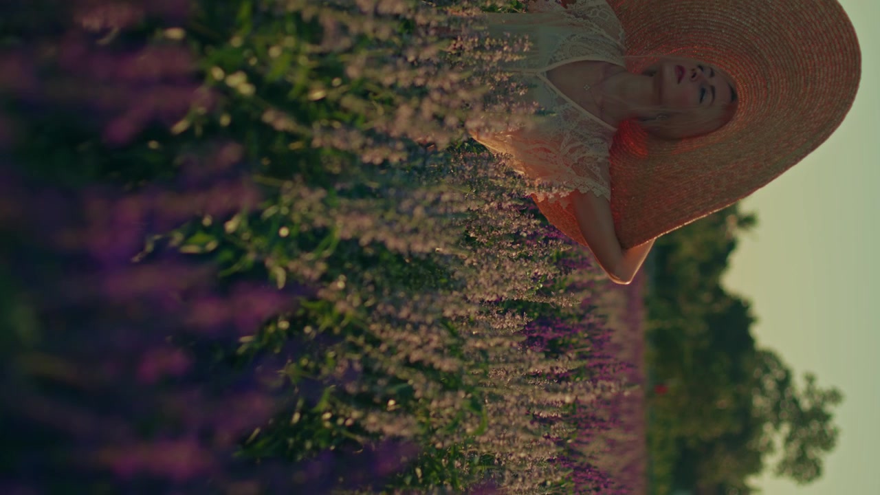 Woman in Straw Hat Walking Through Lavender Field
