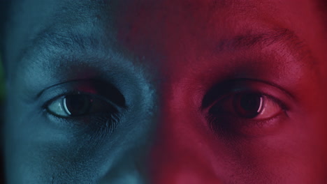 Close-up of a person's face with split-toned neon lighting