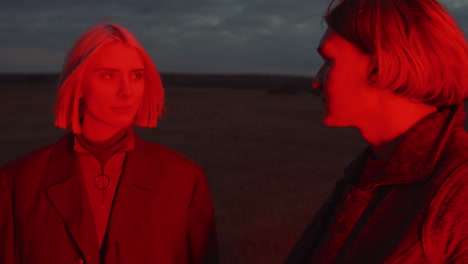 young man and woman looking at each other in red light