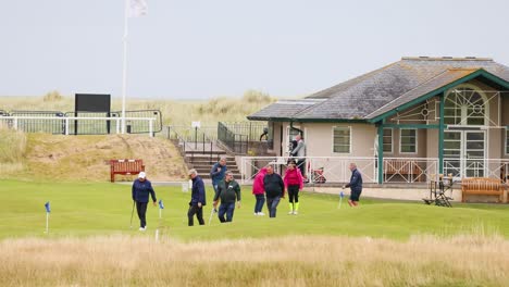 grupo de golfistas caminando por el campo histórico